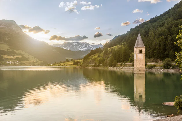 Der Reschensee mit dem berühmten Kirchturm, fotografiert an einem sonnigen Tag im Vinschgau