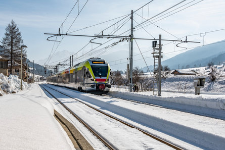 South Tyrolean train arriving in the station surrounded by a snowy landscape