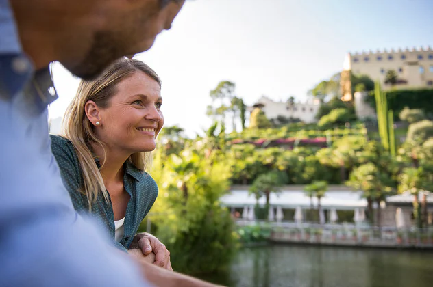 Zwei Personen blicken zu den Gärten von Schloss Trauttmandorff