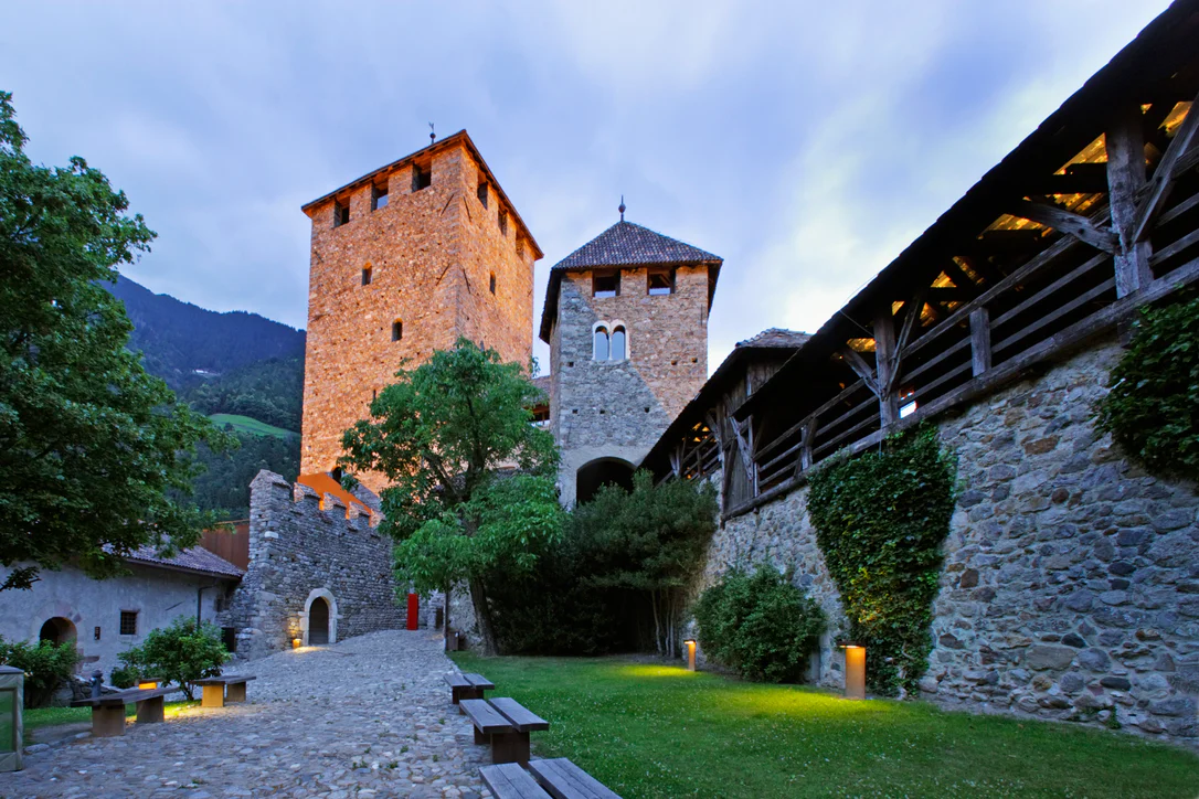 Vista sull'ingresso e la torre principale di Castel Tirolo illuminata