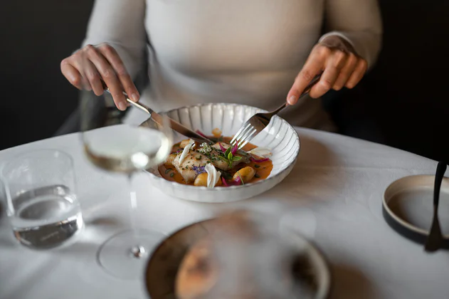 Eine Frau isst ein in Südtirol zubereitetes Gourmetgericht