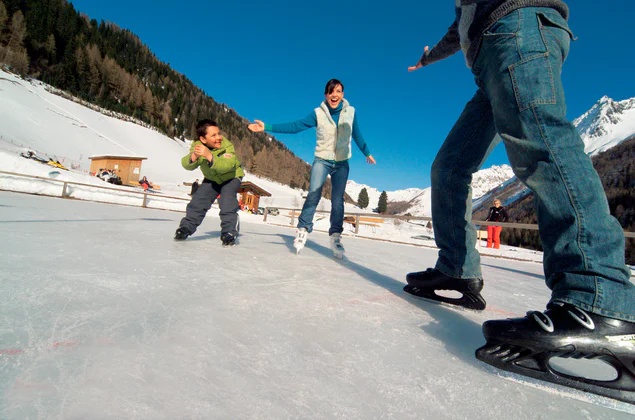 Twee volwassenen en een kind aan het schaatsen