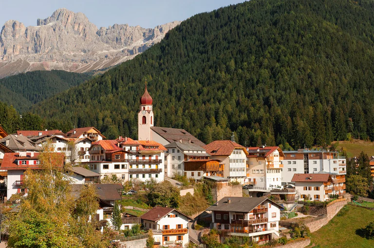 The historic center of Welschnofen and the Dolomites in the background
