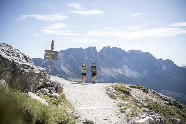 Zwei Personen wandern auf einem Wanderweg in den Bergen