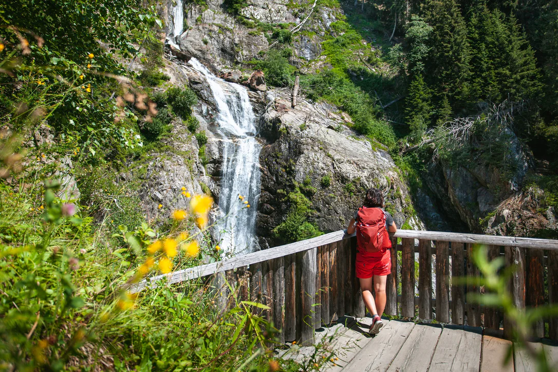 Una persona ammira una cascata nella Valle di Anterselva