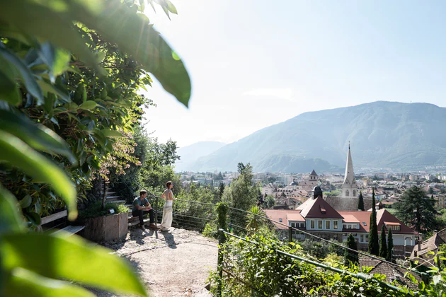 Un uomo e una donna ammirano la vista sulla città di Bolzano dalla passeggiata del Guncina