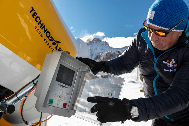 Założyciel firmy TechnoAlpin Georg Eisath obsługuje armatkę śnieżną, wyprodukowaną w jego firmie, stojąc przy trasie narciarskiej. 
