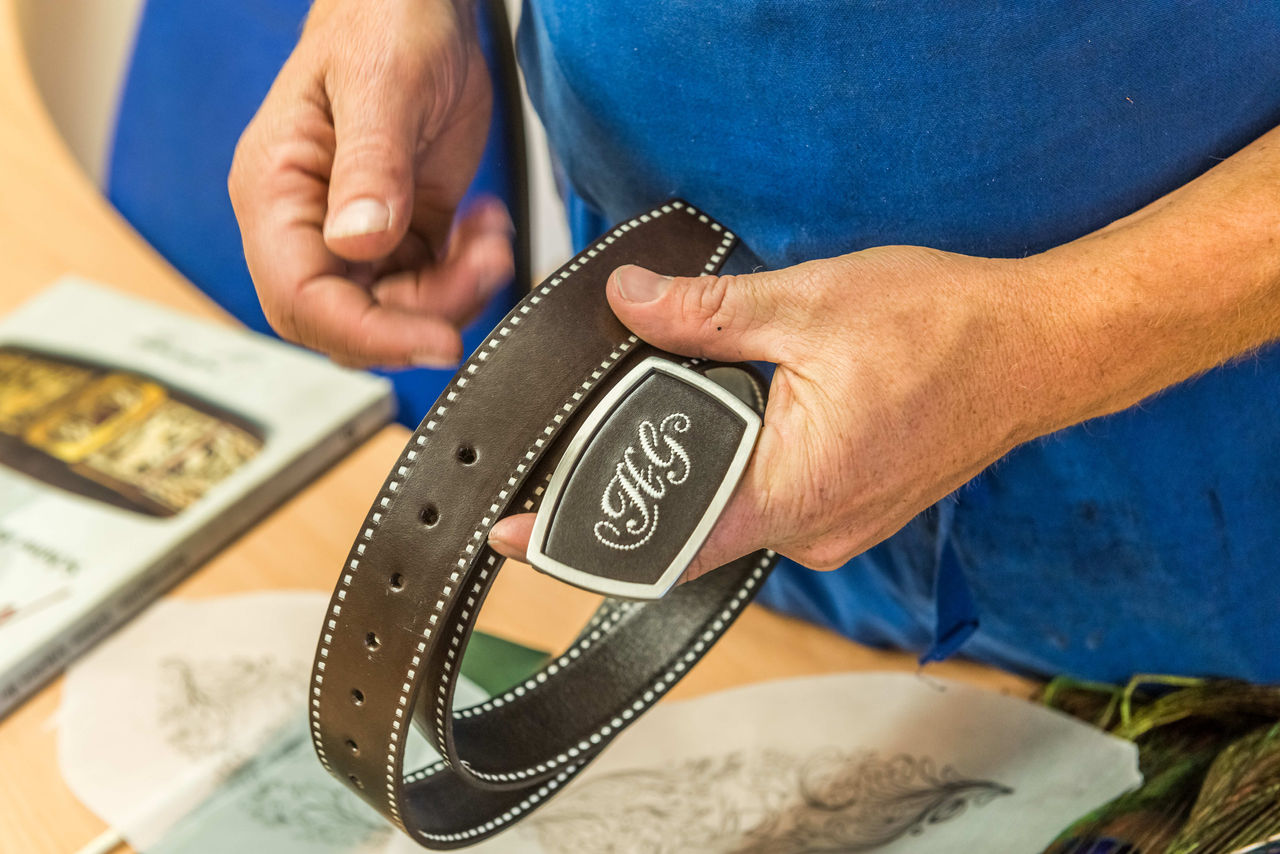 Someone holding a leather belt with an engraving