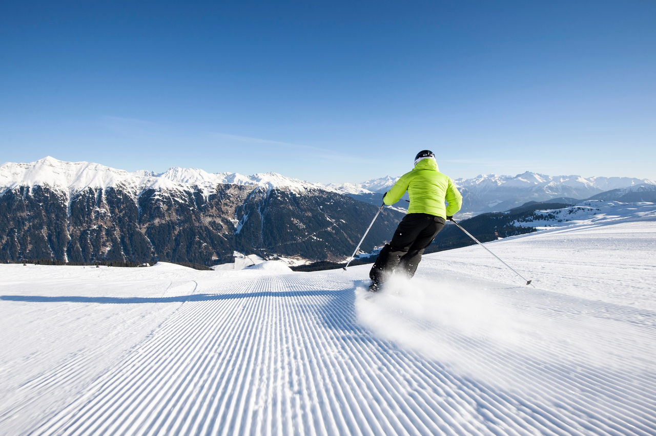 Ein Skifahrer saust über eine Piste in Ratschings vor einem traumhaften Alpenpanorama.