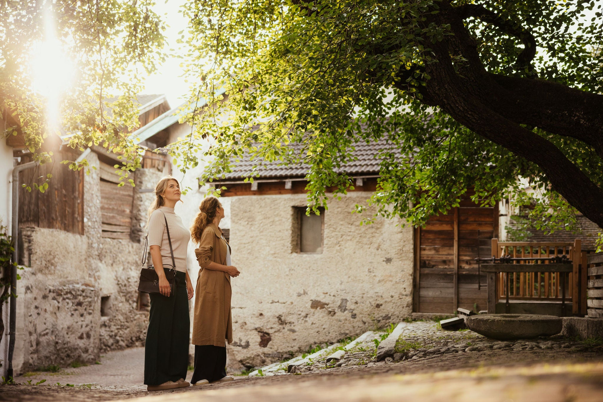 Zwei junge Frauen bestaunen einen idyllischen Platz im Ortskern von Glurns.
