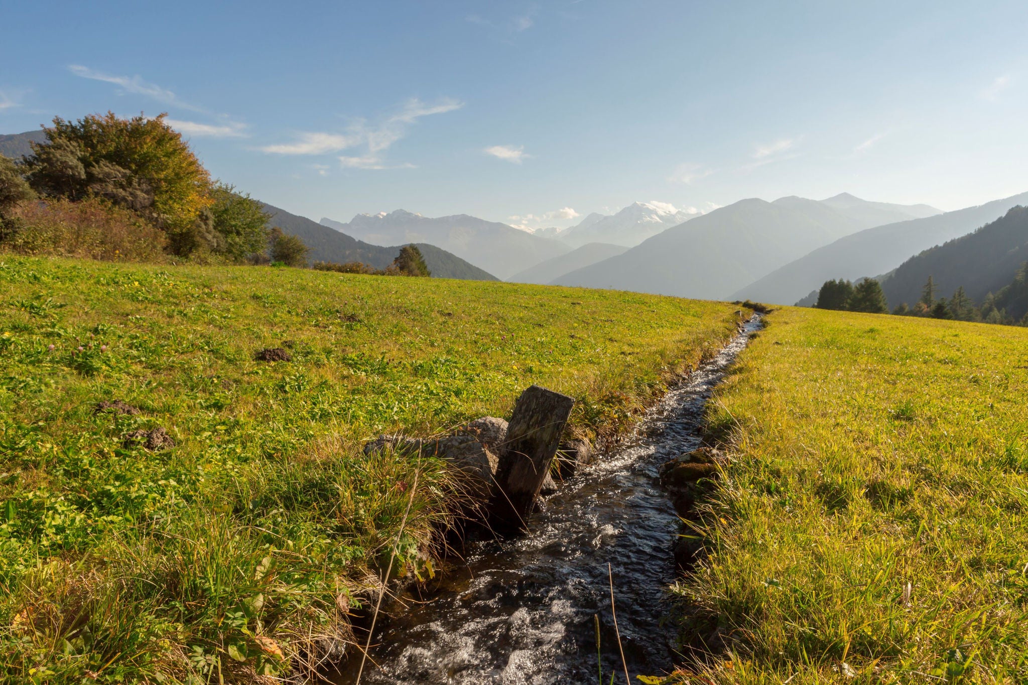 Ein Bewässerungskanal im Vinschgau mit Blick auf die Berge