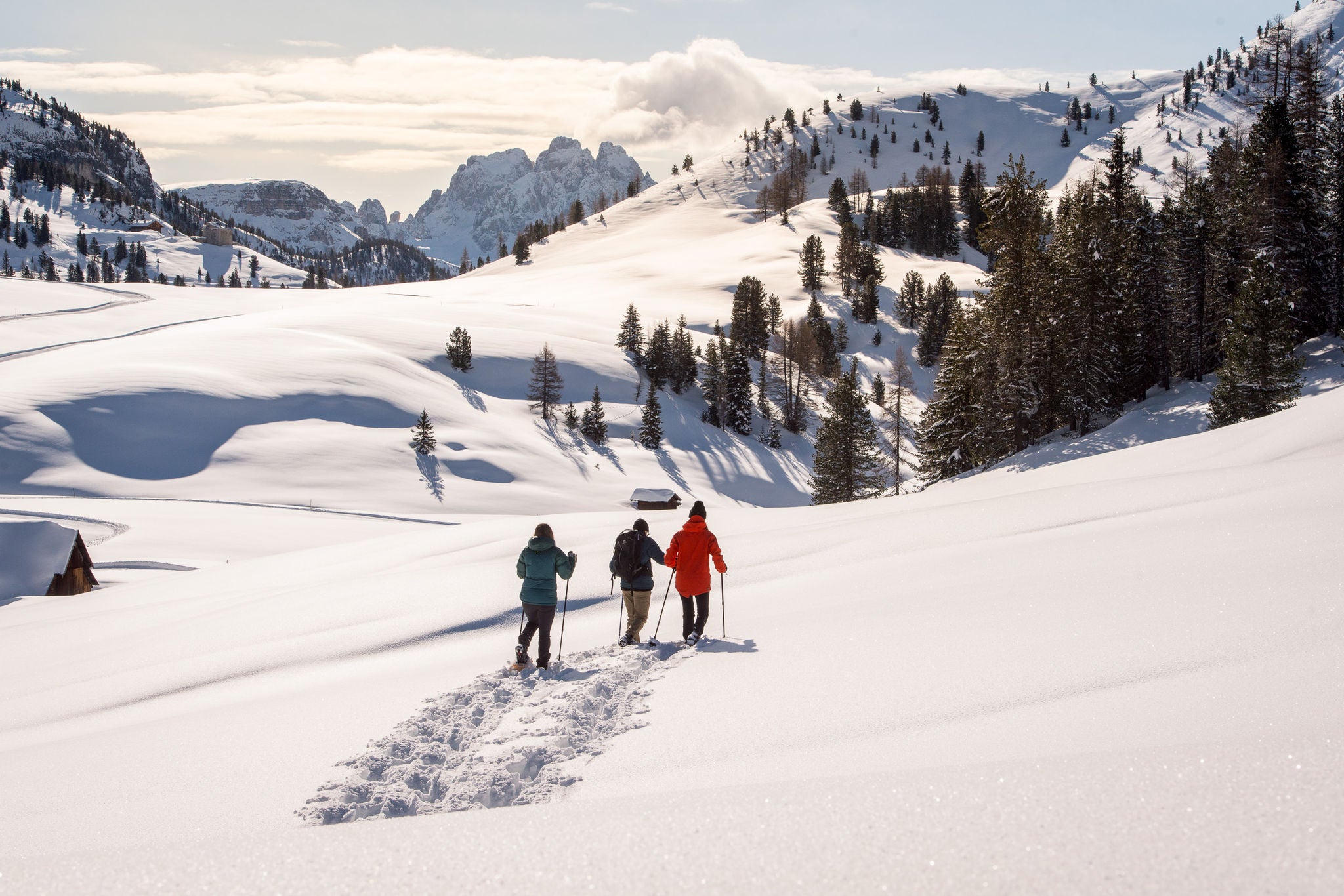 Drei Personen beim Schneeschuhwandern im Pragser Tal