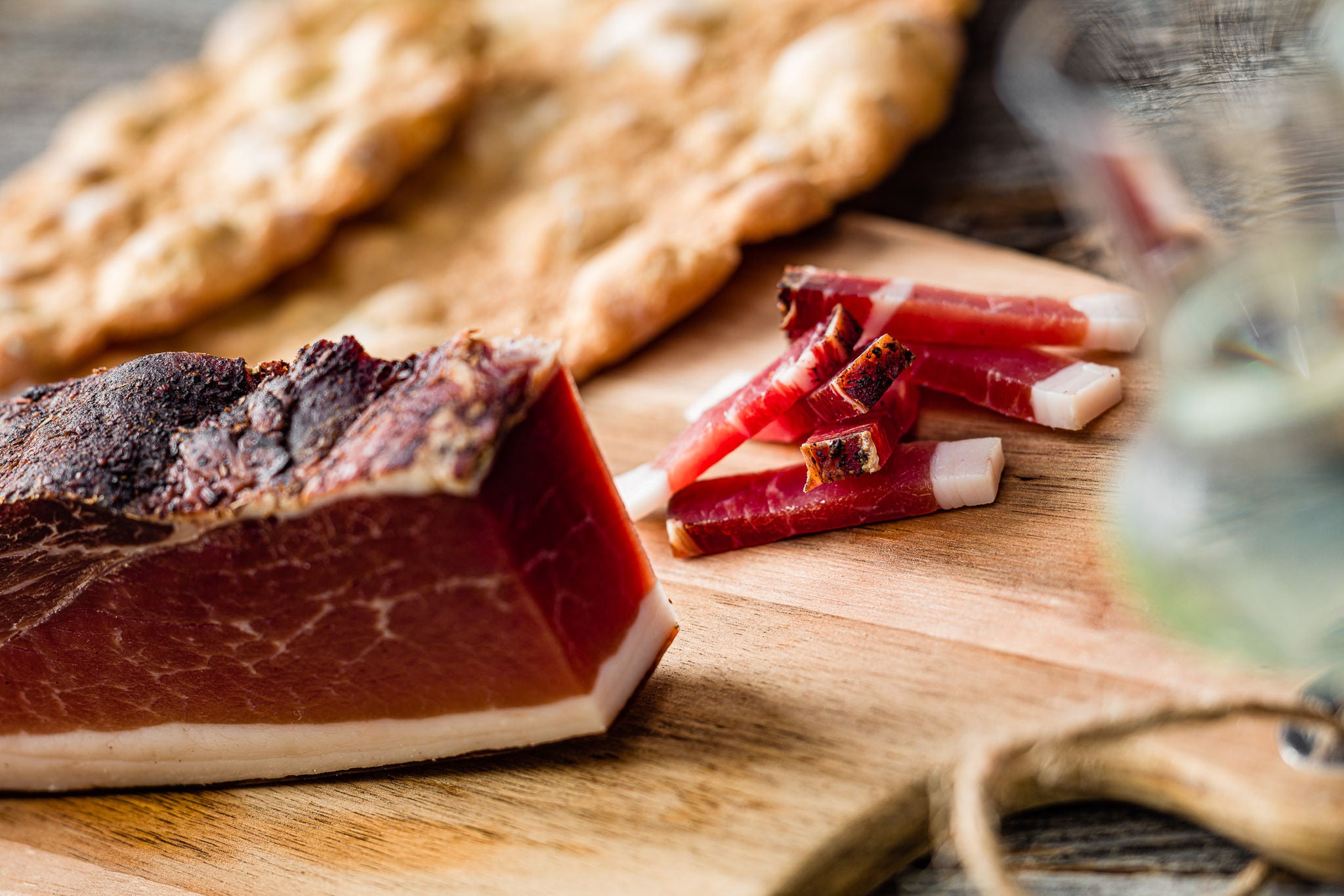 Eingeschnittener Marende Speck und Schüttelbrot liegen auf einem Holzbrett