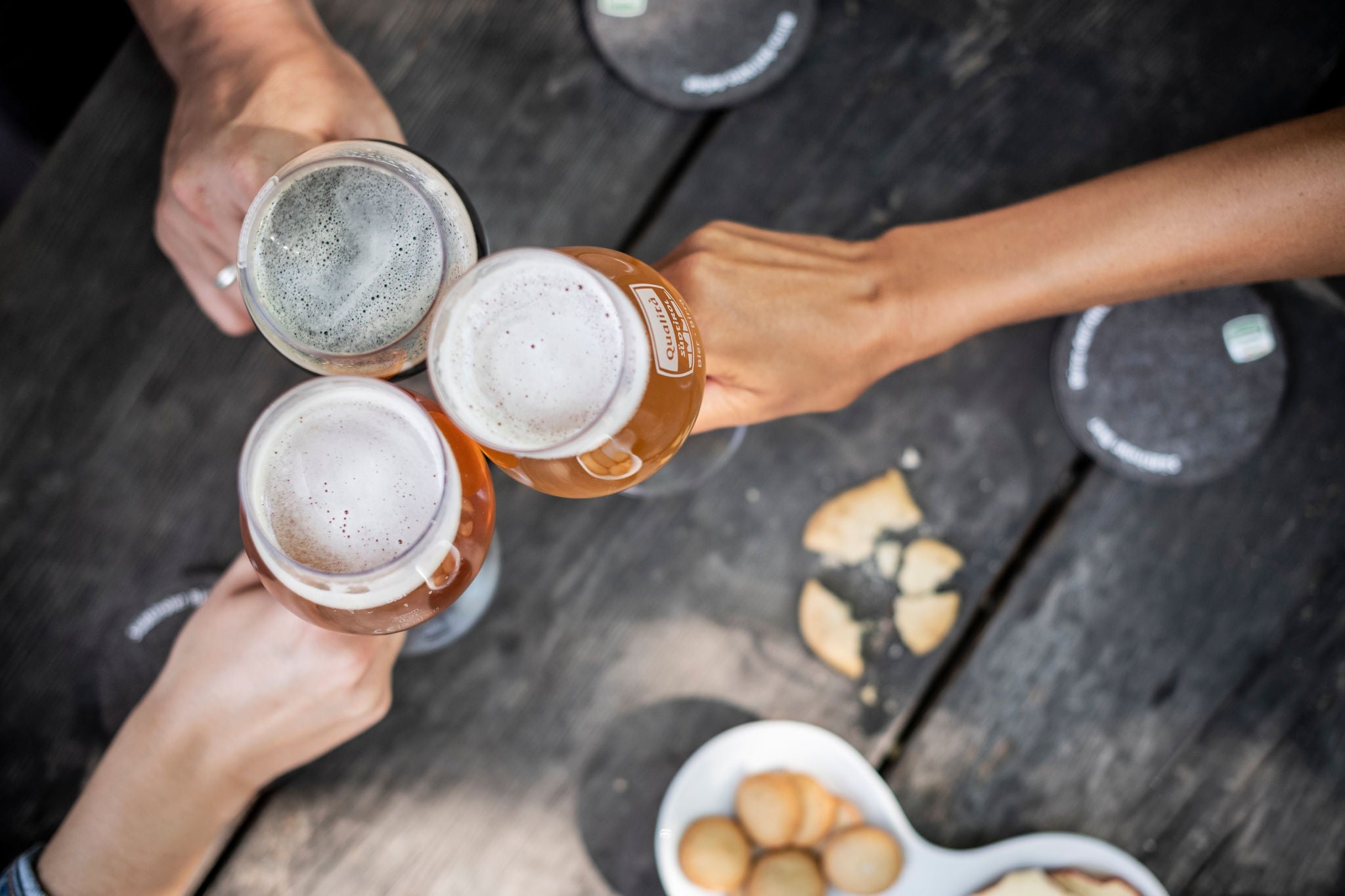 Drei Personen stoßen mit Bier an