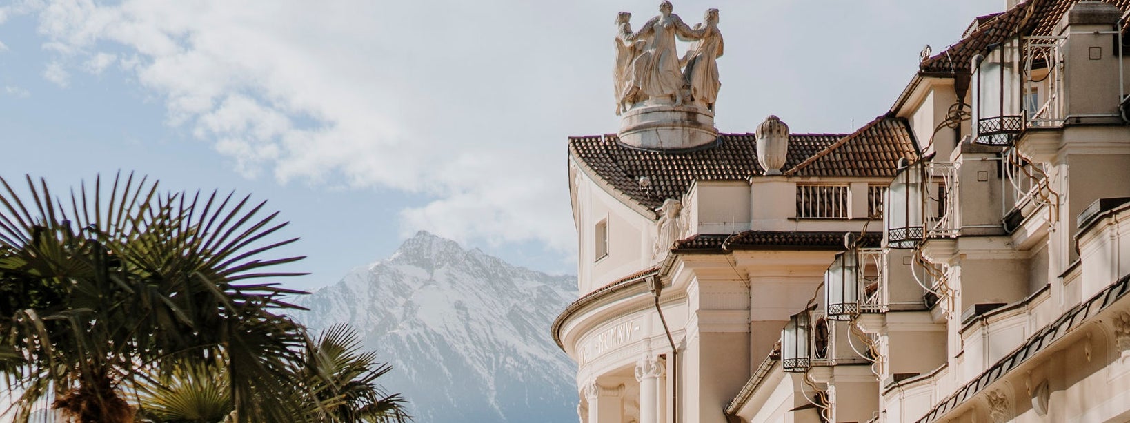 Das prächtige Kurhaus im Jugendstil unter blauem Himmel und von Palmen umgeben.