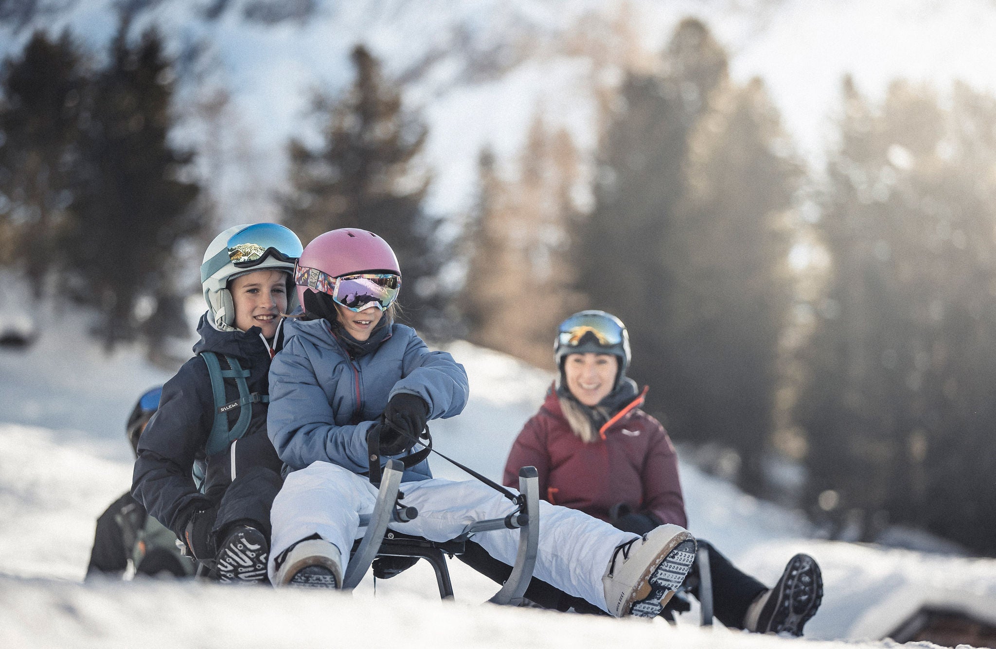 Eine Familie auf einer Rodelbahn in den Dolomiten