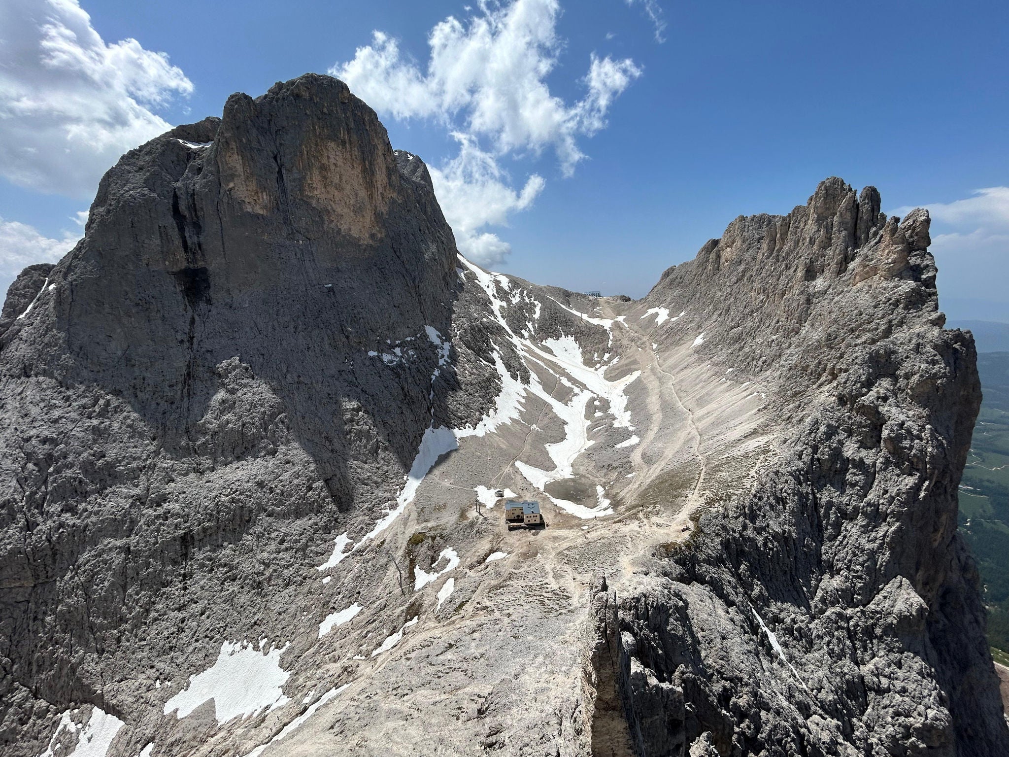 Vista panoramica su Catinaccio e Croda di Re Laurino con il rifugio Re Alberto I in primo piano e il Rifugio Passo Santner in lontananza