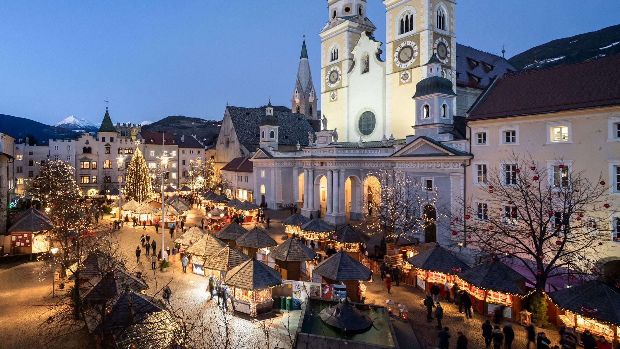 Der Christkindlmarkt in Brixen vor den beleuchteten Türmen des Doms.