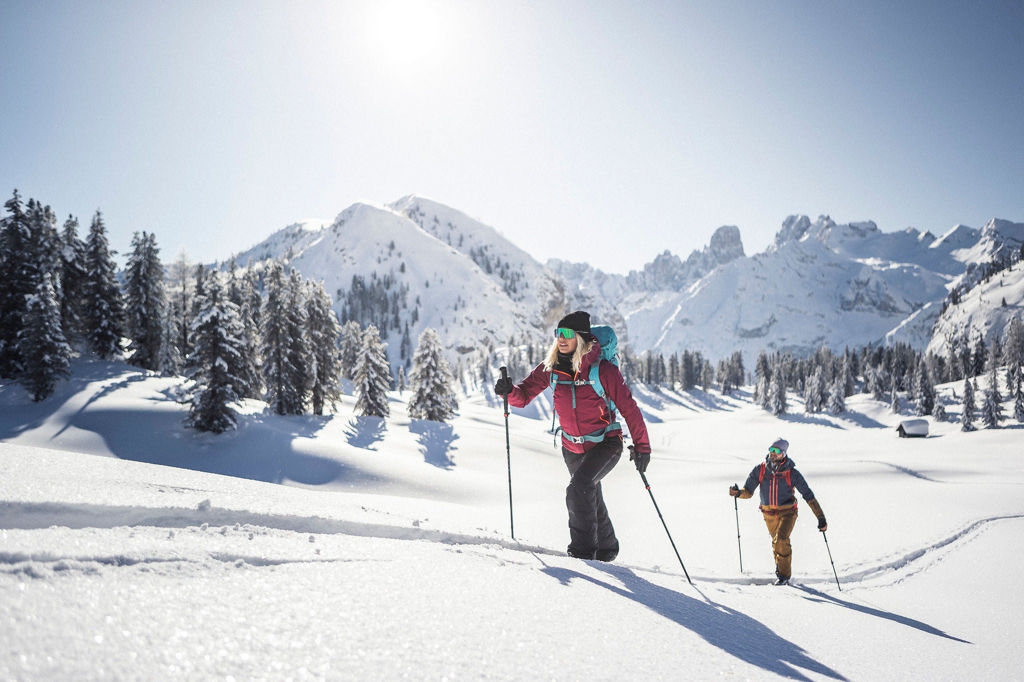 Eine Frau und ein Mann sind mit ihren Langlaufski auf einer Skitour unterwegs.