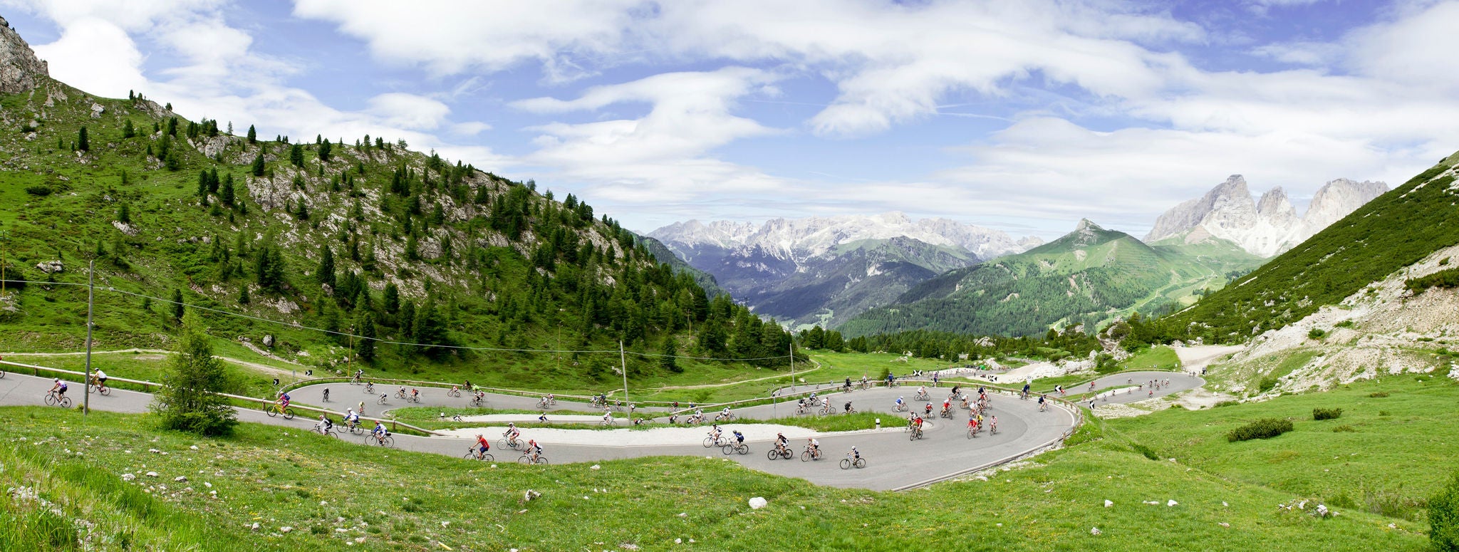 Eine Gruppe von Rennradfahrern bezwingt die kurvenreiche Passtraße auf das Grödnerjoch