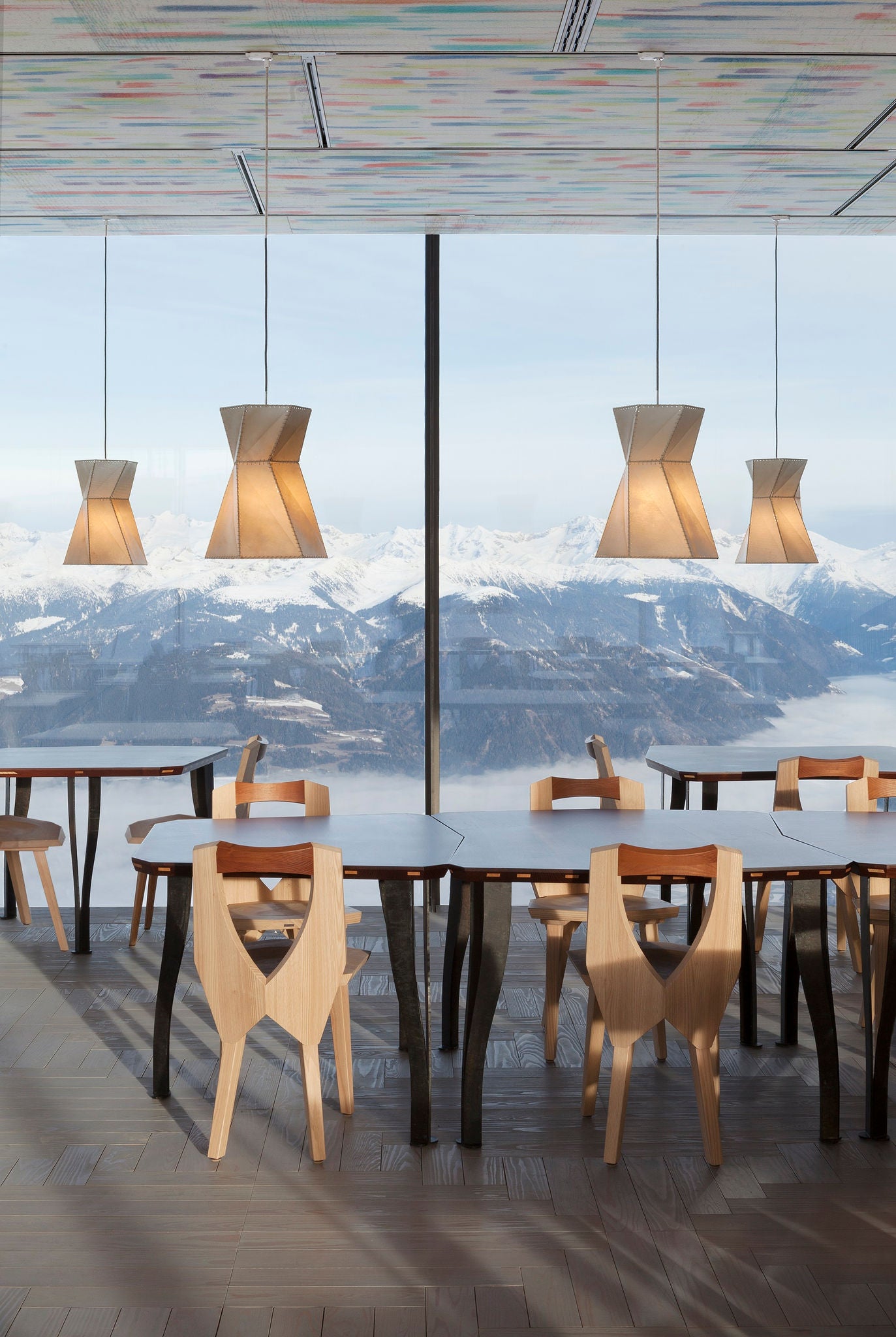 Moderne Einrichtung eines Restaurants mit Panorama auf die umliegenden Berge im Schnee
