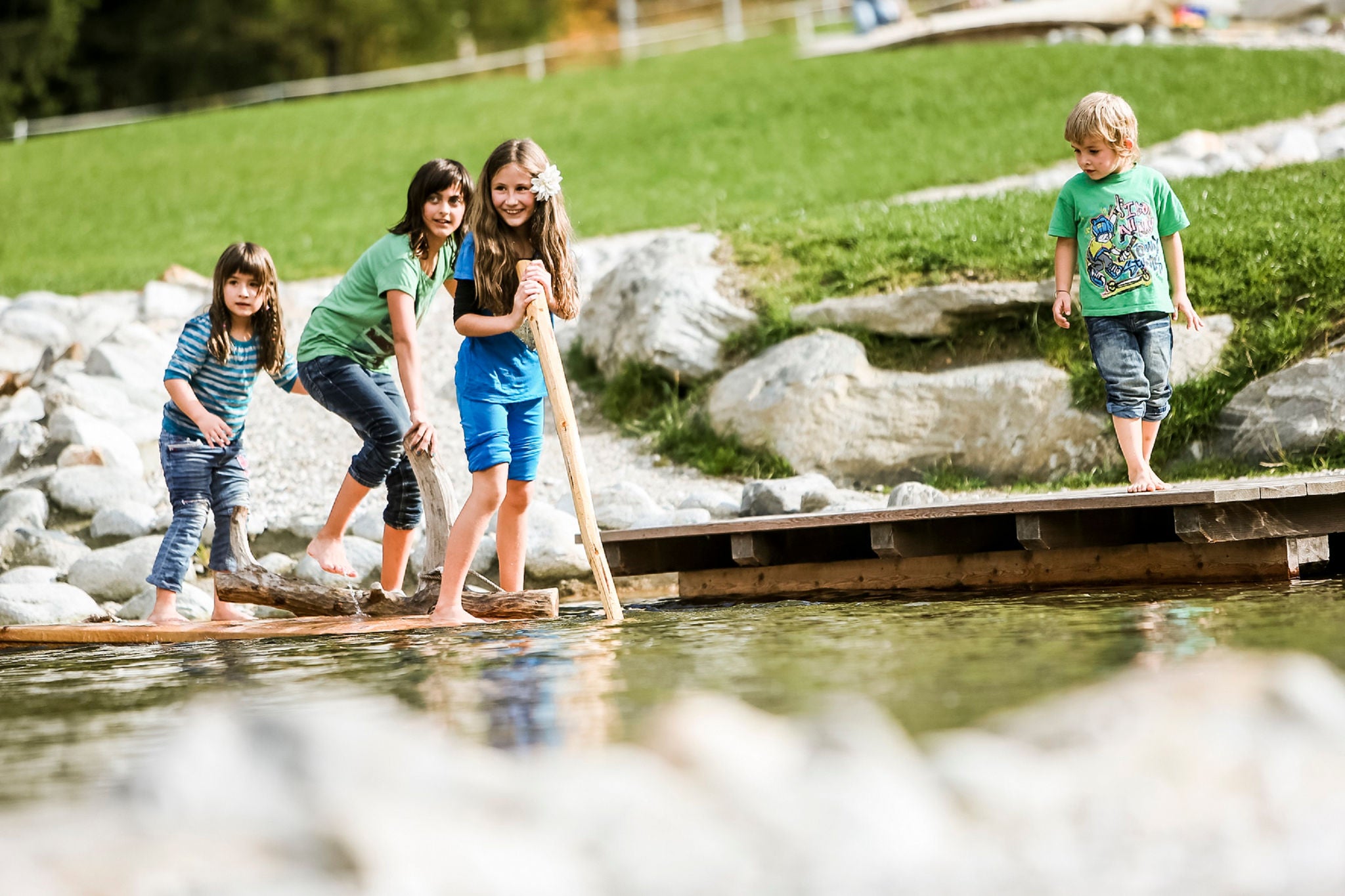 Vier Kinder spielen vergnügt am Wasser in der Ferienregion Tauferer Ahrntal.