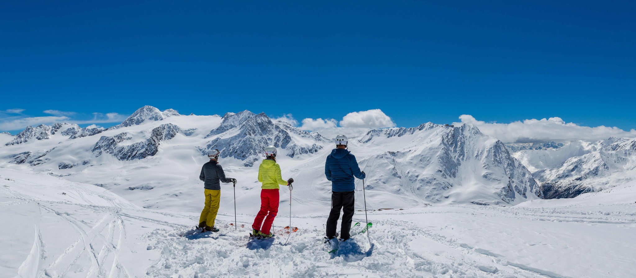 Drei Skifahrer beim Blick auf umliegende Berglandschaft im Skigebiet Schnalstal