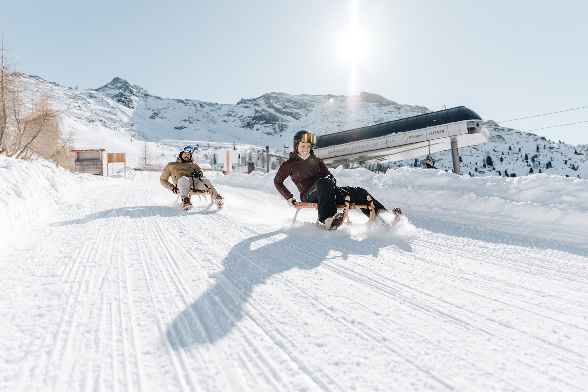Mann und Frau beim Rodeln in Skigebiet