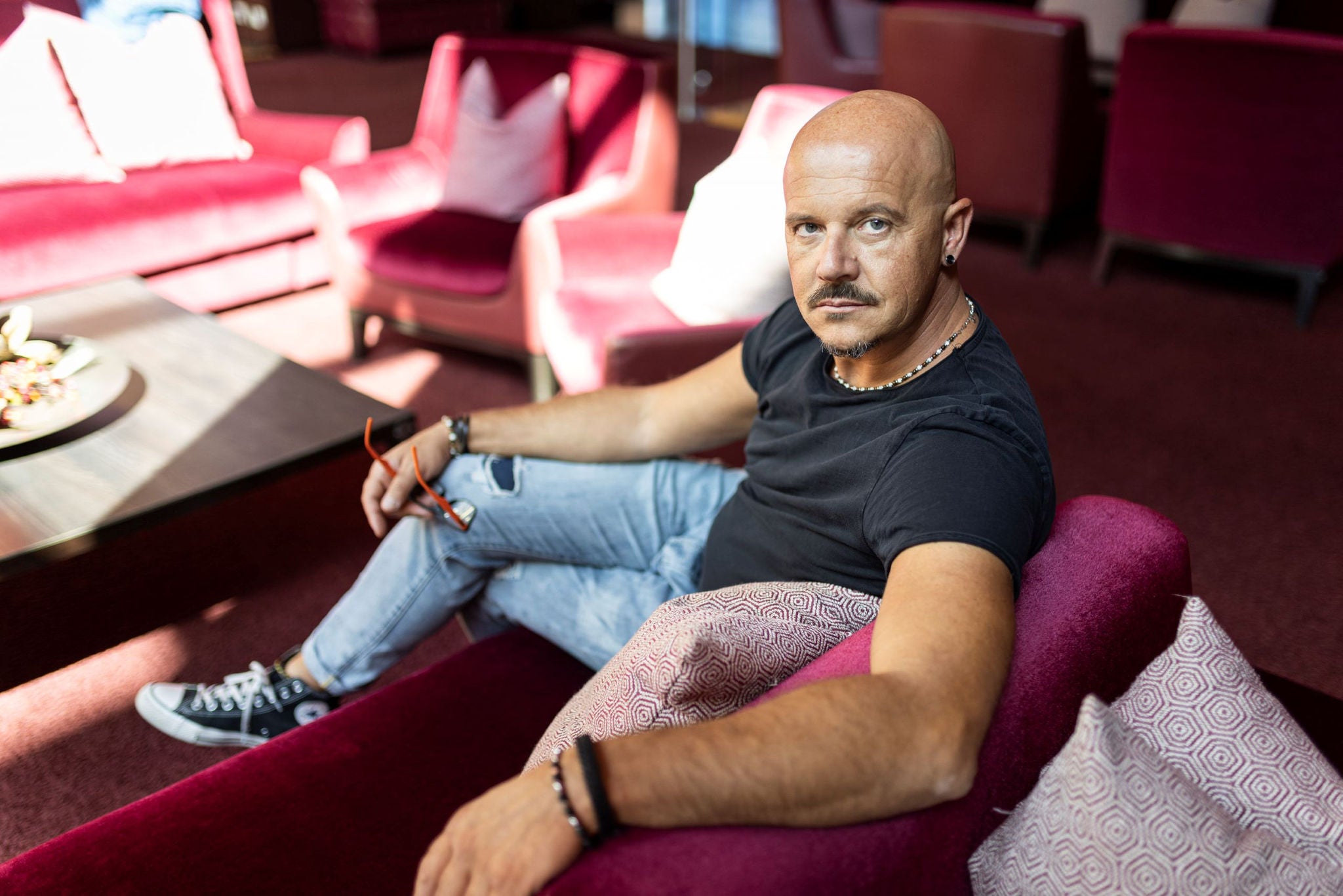 Der Südtiroler Schauspieler und Kabarettist Thomas Hochkofler sitzend auf einer Couch