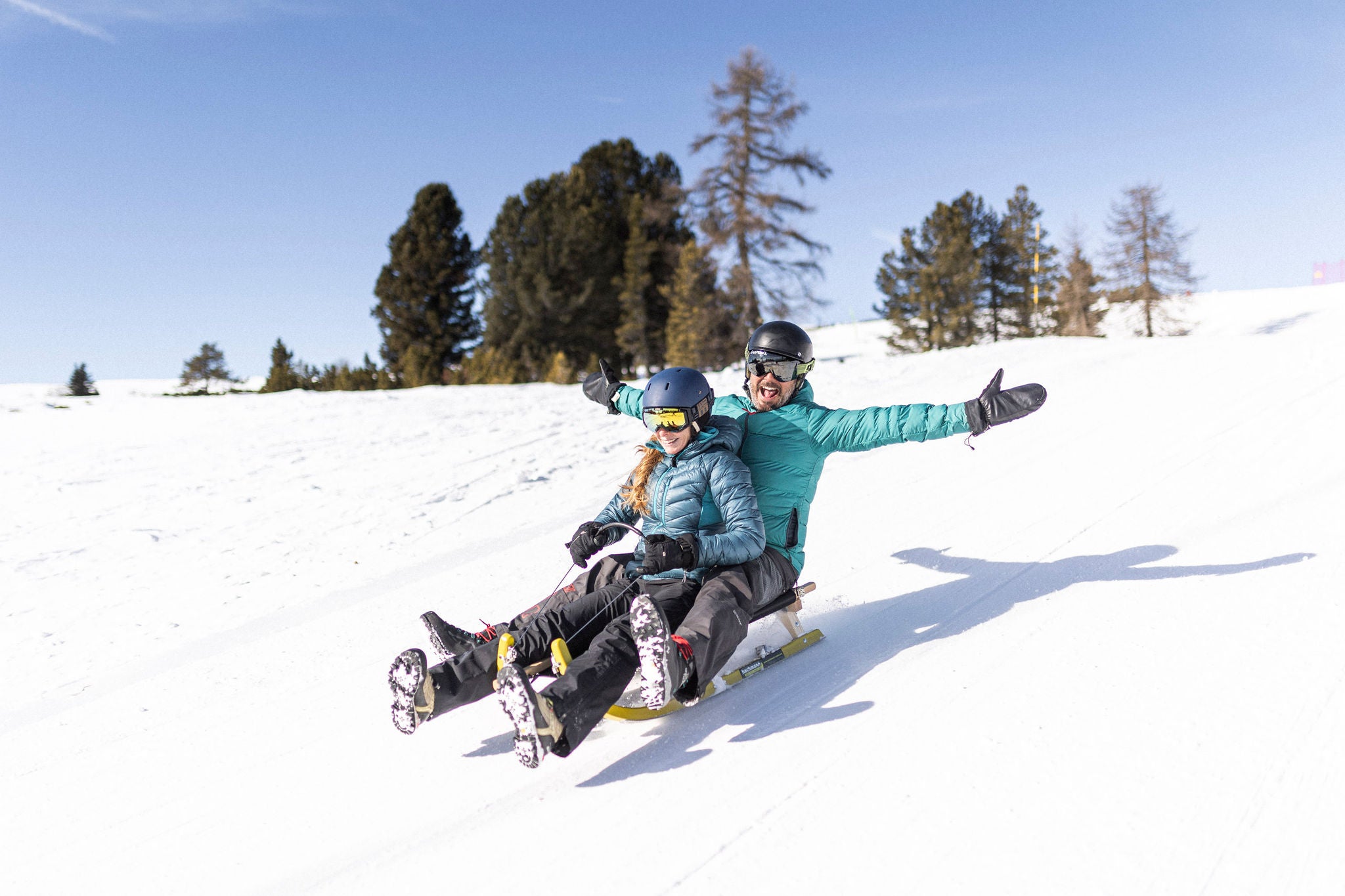 Ein Paar beim Rodeln am Ritten