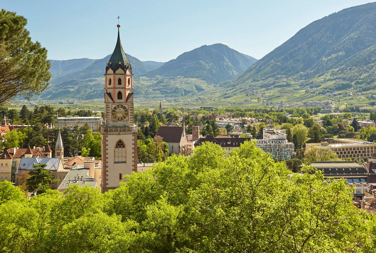 Das Grün der Bäume umrahmt die Kurstadt Meran mit der Pfarrkirche im Zentrum