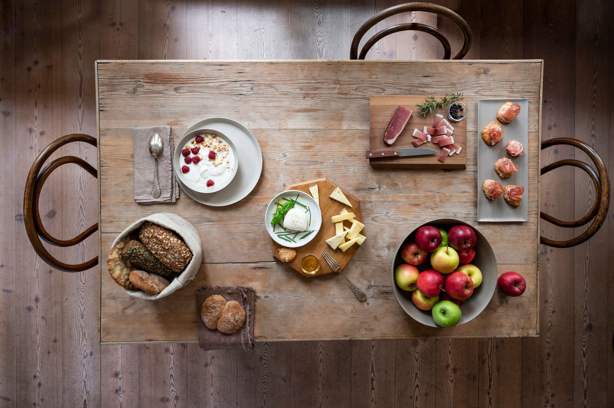 Ein Tisch gedeckt mit Südtiroler Produkte wie Käse, Brot, Äpfeln und Schinken
