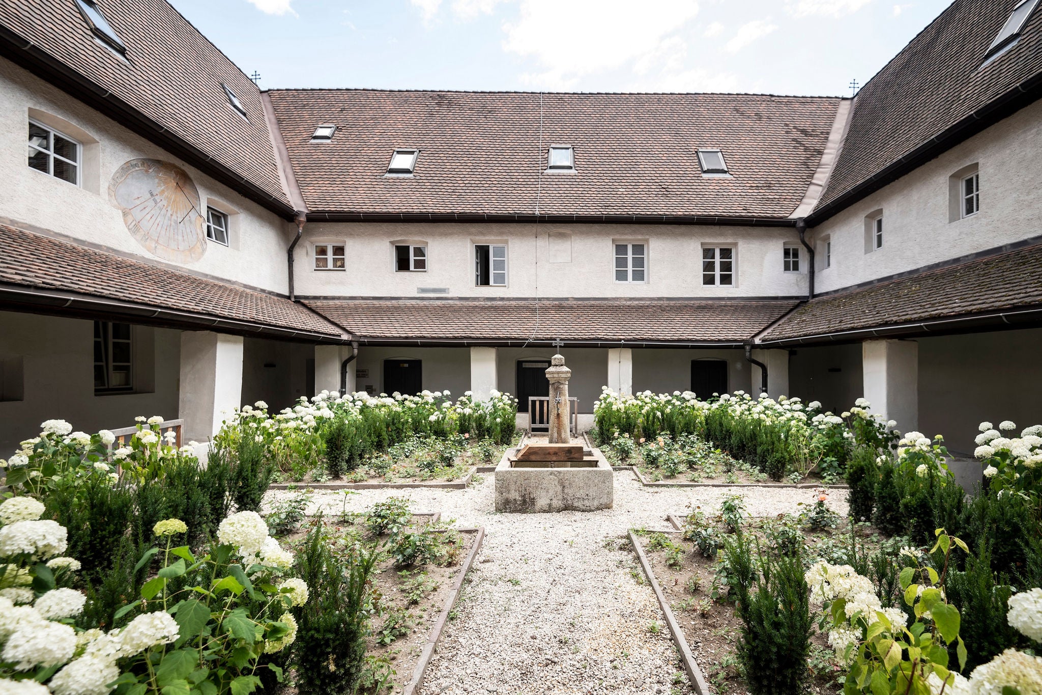 Blumenbeete und Brunnen im arkadengesäumten Innenhofs des Stadtmuseums von Klausen