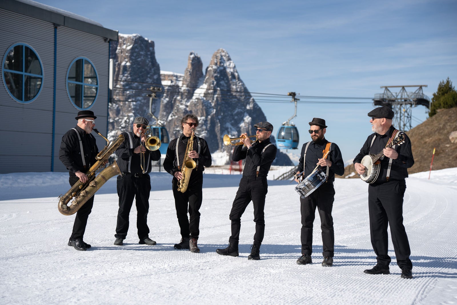Musiker der Veranstaltung Swing on Snow auf einer Piste vor einer Aufstiegsanlage auf der Seiser Alm
