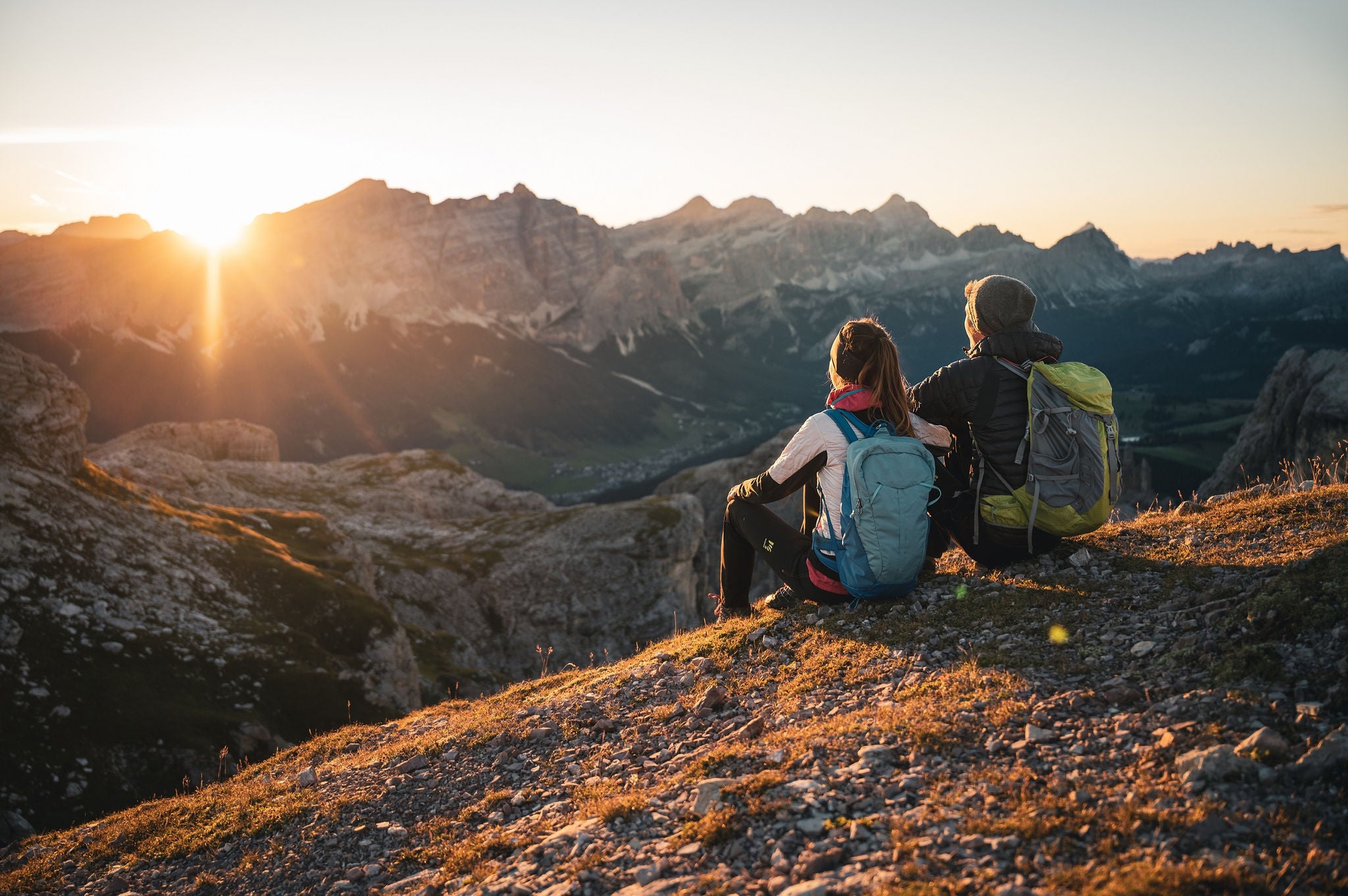 Zwei Personen wandern im Gebirge in Alta Badia bei Sonnenaufgang