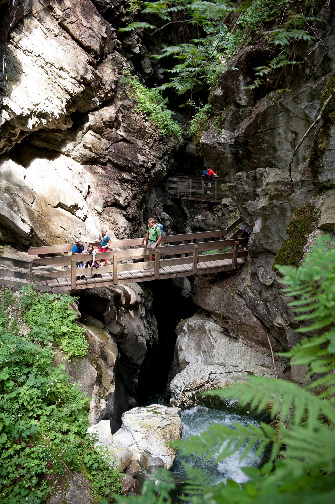 Eine Familie macht einen Ausflug in die Gilfenklamm,  die mittels Brücken und Treppen zugänglich ist.