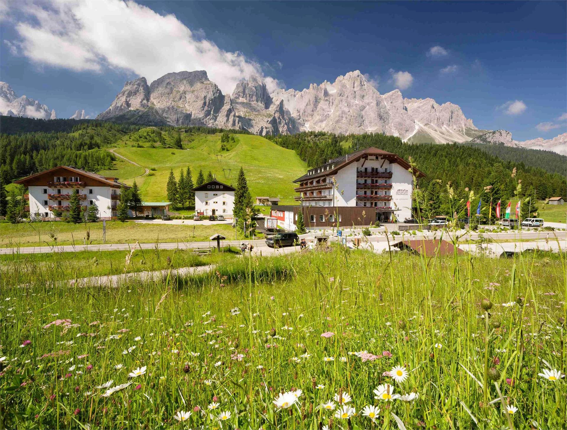 Das Hotel am Kreuzbergpass vor einem alpinen Bergmassiv.
