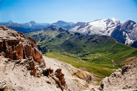 Vista su diverse cime, sulla valle e sul Passo Pordoi che la costeggia. 