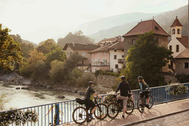 Due persone in bicicletta su un ponte