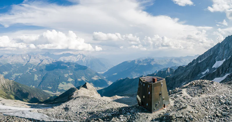 Il Rifugio Sasso Nero in primo piano con un vasto panorama sullo sfondo