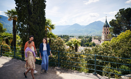 A woman and a man enjoy the view of Meran from the Tappeinerweg trail.