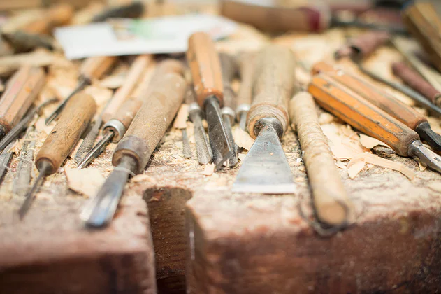 Nahaufnahme des Werkzeugs zum Holzschnitzen auf einer Bank