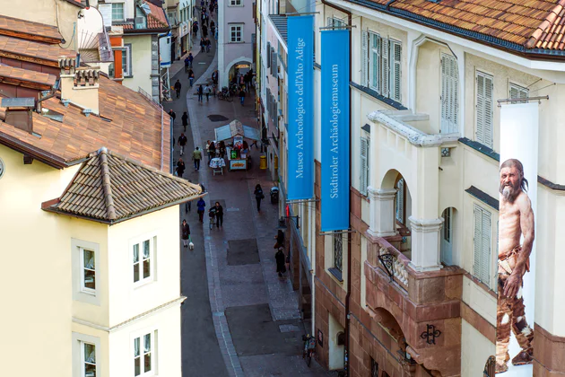 Vista su via Museo, sulla destra il palazzo dell'Museo Archeologico dell'Alto Adige dove svetta una bandiera della mummia Ötzi
