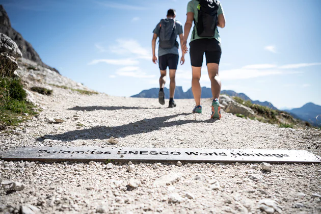 View of two walkers running the Dolomites UNESCO World Heritage hike