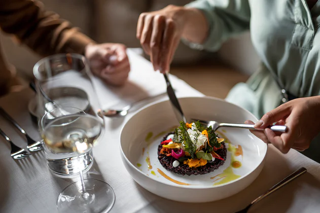 Una donna gusta un risotto nero e petali