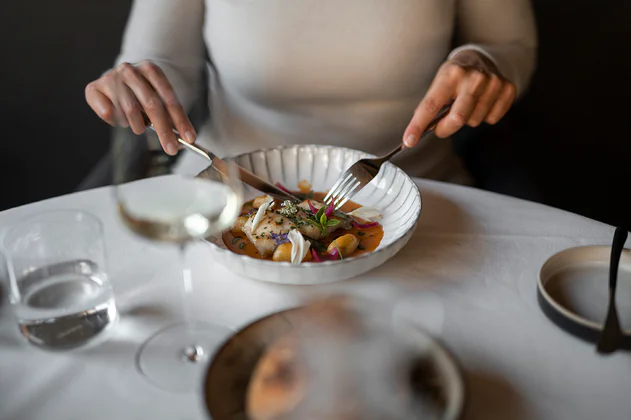 One person is sitting at a table and eating local food