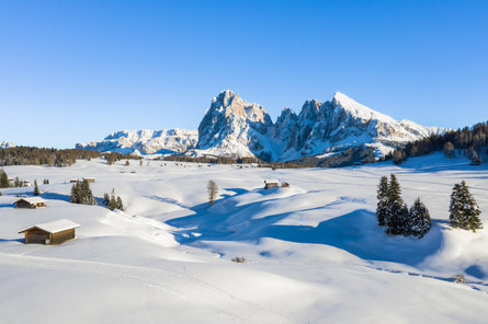 Een besneeuwde Seiser Alm met de bergen Langkofel en Plattkofel