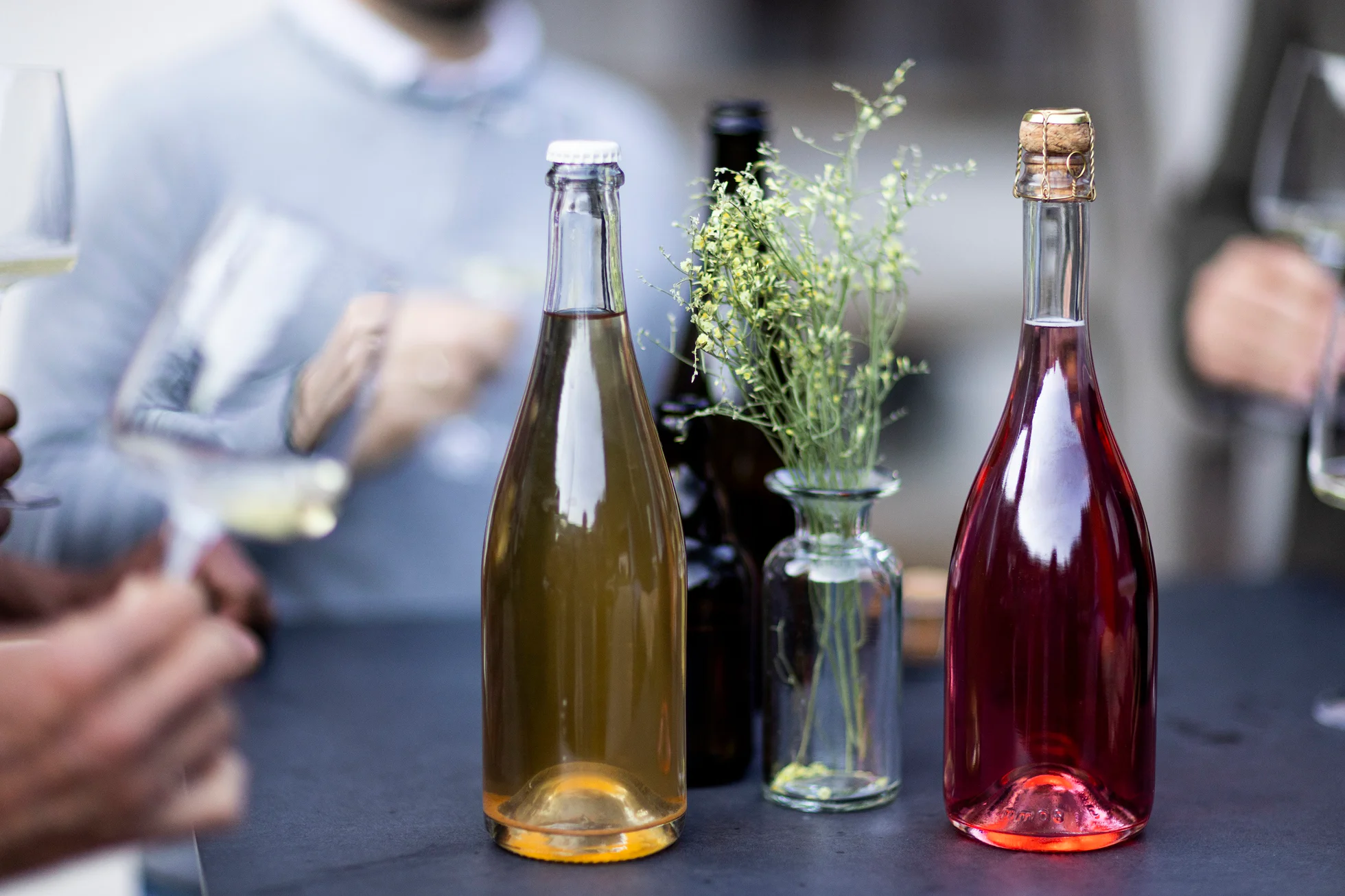 Mehrere Personen die an einem Tisch mit Südtiroler Cider Flaschen stehen und anstoßen