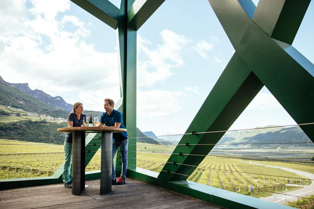 Kobieta i mężczyzna degustują wino w nowoczesnym kompleksie architektonicznym wytwórni wina Kellerei Tramin
