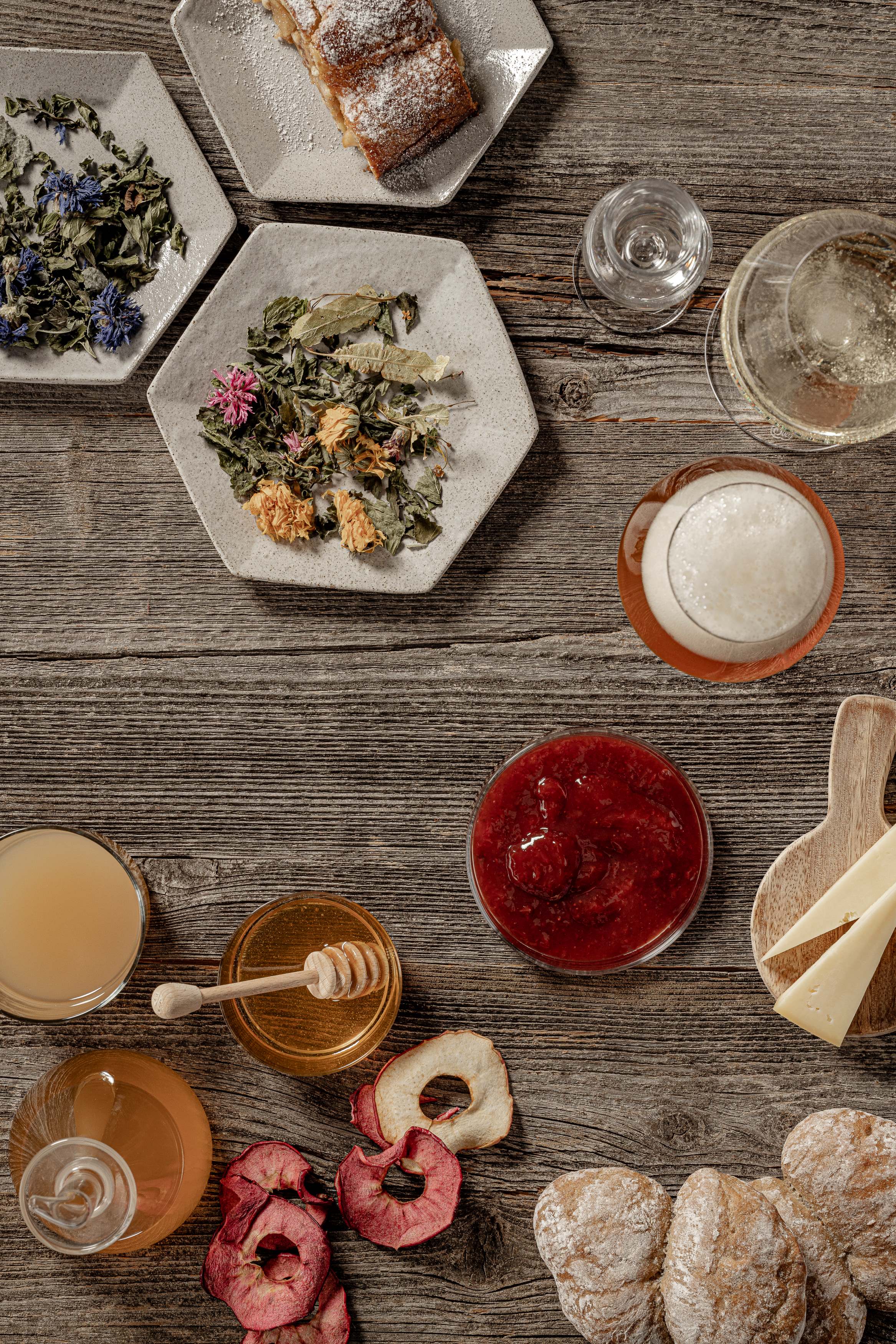 Südtiroler Produkte sind auf einem Tisch angerichtet, darunter Käse, Honig, Wildkräuter und Fleisch. 